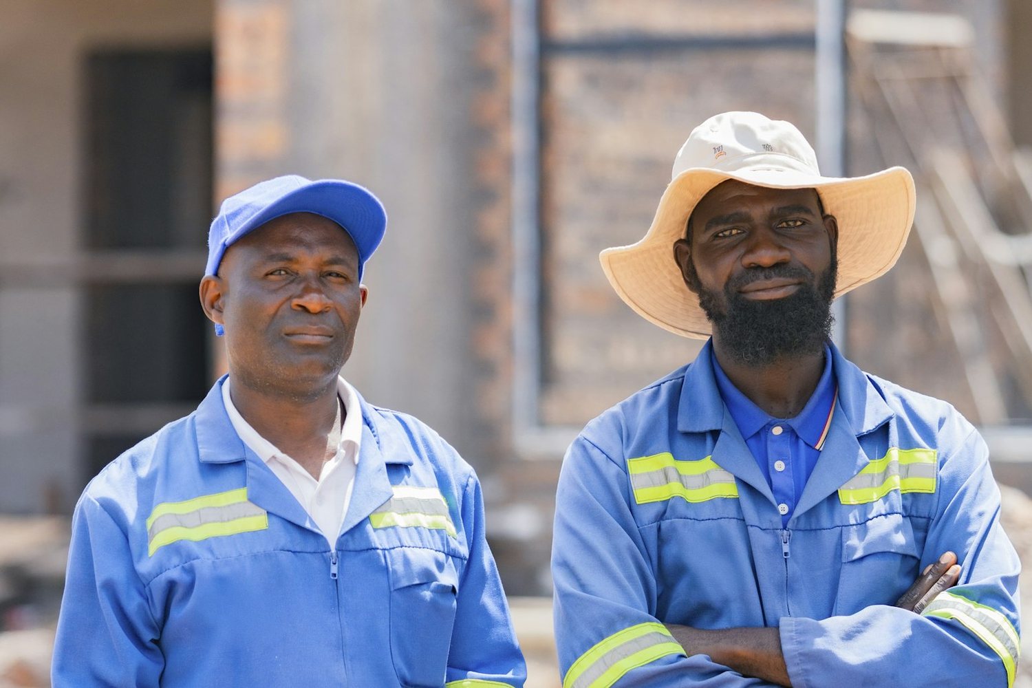 Two technicians in branded coveralls and caps