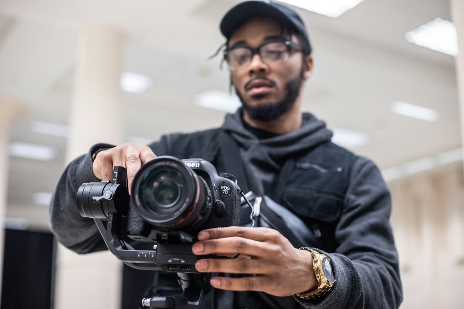 Videographer operating a camera rig indoors