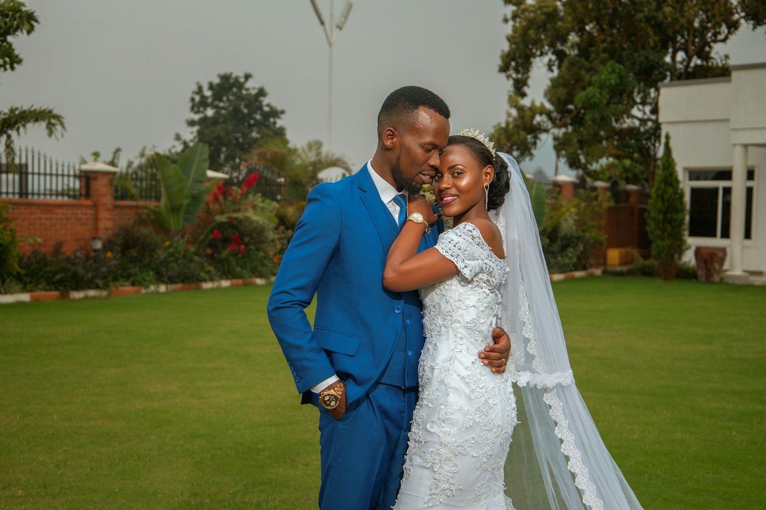 Bride and groom embracing on a garden lawn