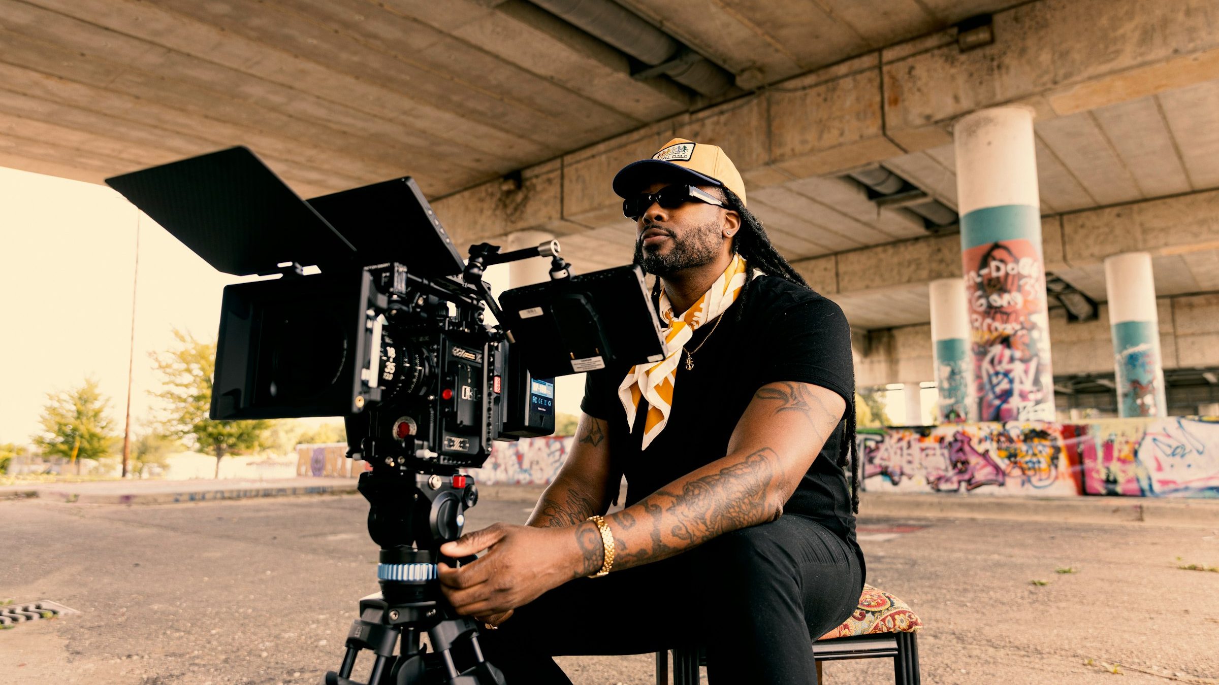 Cinematographer seated behind a cinema camera on location