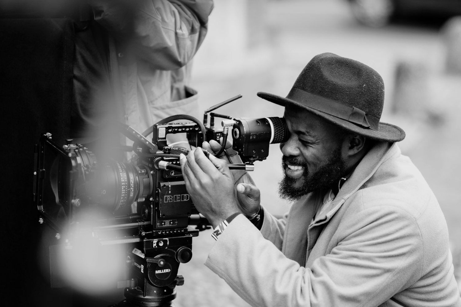 Filmmaker in a hat working a cinema camera