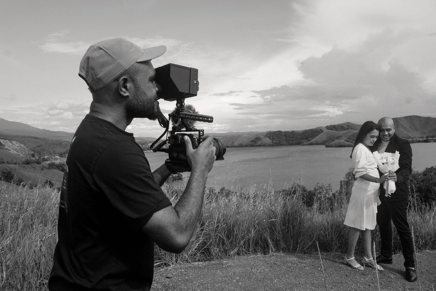 Videographer filming a bride and groom outdoors