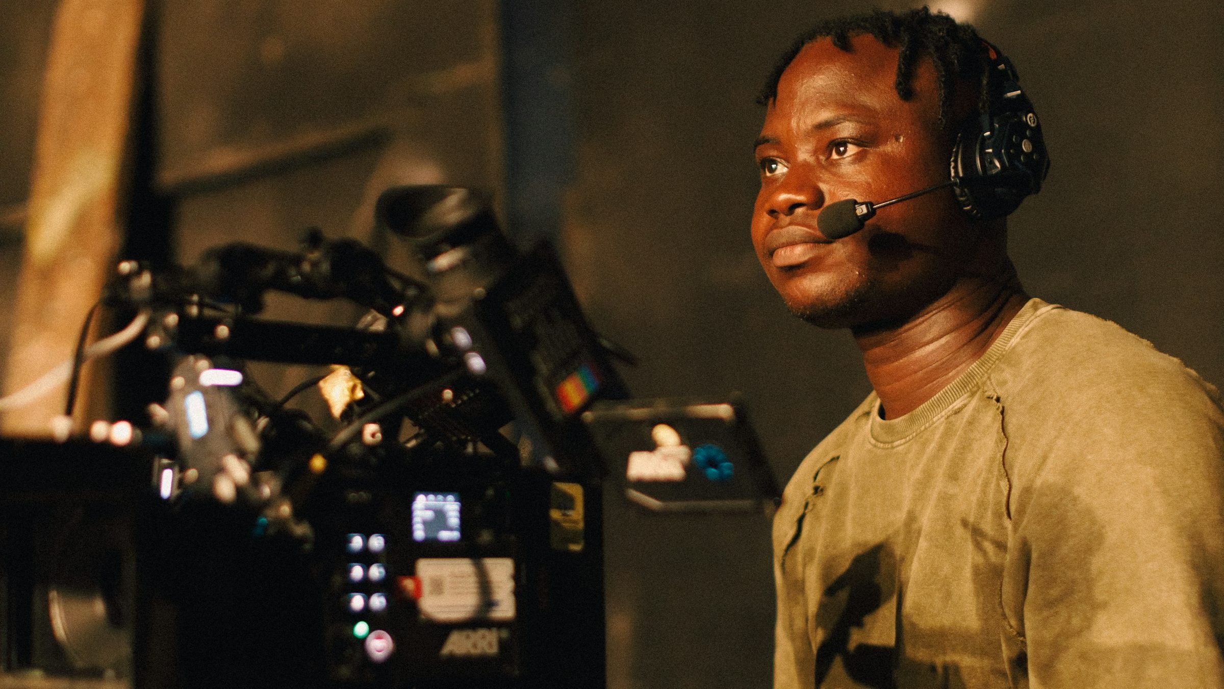 Camera operator with headset beside a cinema camera